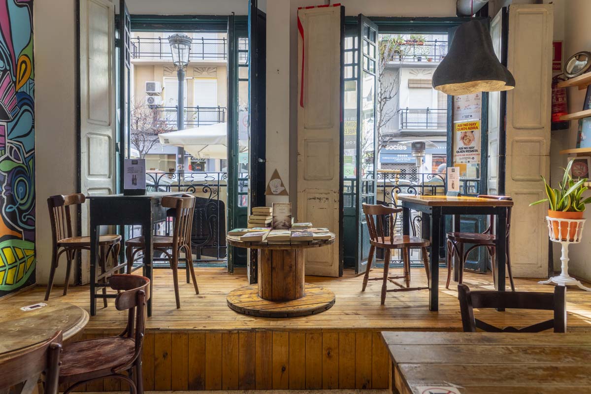 Image of the interior of Ubik Café where some windows, some tables and books appear